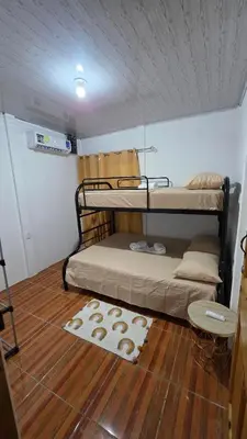 a room with two bunk beds and a wooden floor at Casa Brisa Azul 5 minutes from the beach in La Cruz