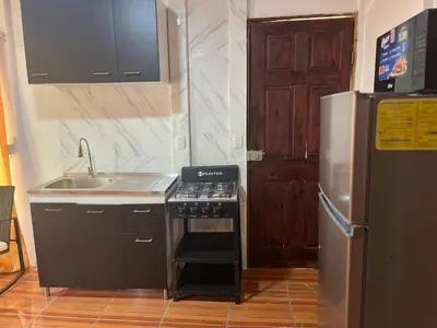 a kitchen with a stove and a sink and a refrigerator at Casa Brisa Azul 5 minutes from the beach in La Cruz