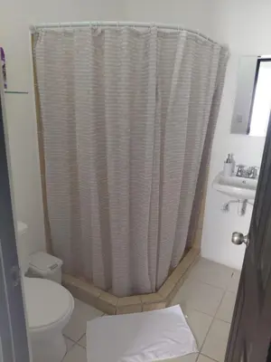 a bathroom with a shower curtain and a toilet at Sunset House Herradura in Herradura