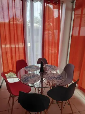 a glass table and chairs in a room with windows at Sunset House Herradura in Herradura