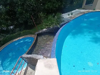 two large blue swimming pools with stairs in them at Sunset House Herradura in Herradura