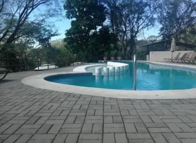 a swimming pool with blue water in a yard at Sunset House Herradura in Herradura