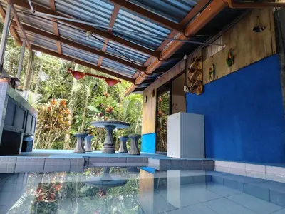 a house with a pool and a blue wall at Vértice Blue Mountain Lodge in San Lorenzo
