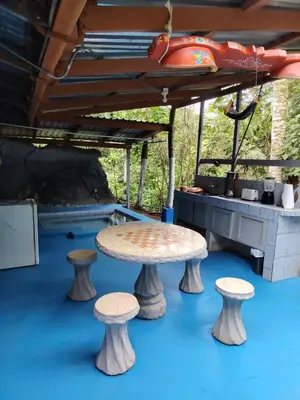 a table and two stools on a blue floor at Vértice Blue Mountain Lodge in San Lorenzo
