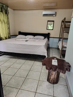 a bedroom with a bed and a wooden table at Vértice Blue Mountain Lodge in San Lorenzo