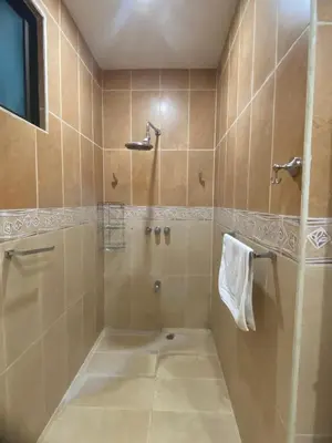 a tiled bathroom with a shower and a sink at Fun in the sun, ground floor, 2 Bedroom, with pool, close to ocean in Coco