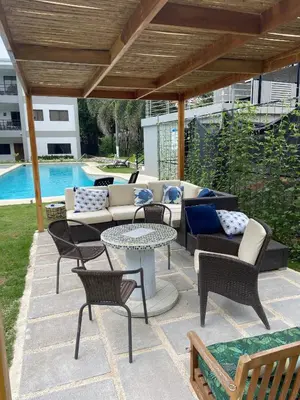 a patio with couches and a table and chairs at Fun in the sun, ground floor, 2 Bedroom, with pool, close to ocean in Coco