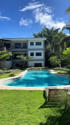 a house with a swimming pool in front of a building at Fun in the sun, ground floor, 2 Bedroom, with pool, close to ocean in Coco