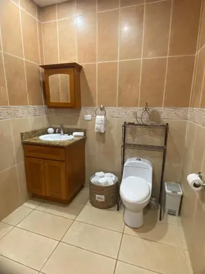 a bathroom with a toilet and a sink at Fun in the sun, ground floor, 2 Bedroom, with pool, close to ocean in Coco