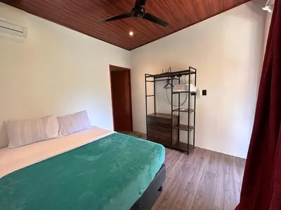 a bedroom with a bed and a shelf in it at Hospedaje Quepos Tardes Doradas in Quepos
