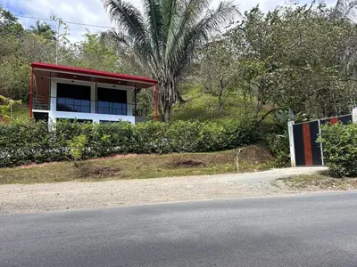 a red and white building on the side of a road at Hospedaje Quepos Tardes Doradas in Quepos