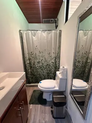 a bathroom with a toilet and a shower at Hospedaje Quepos Tardes Doradas in Quepos