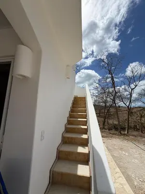a staircase leading up to a white building with a blue sky at Villa Sol Kite House in La Cruz