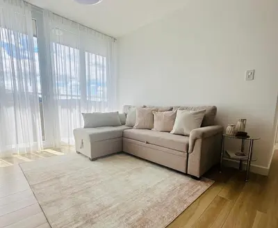 a living room with a couch in a room with windows at Secure & Confortable Apartment with green spaces in San Rafael