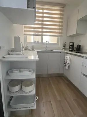 a kitchen with white cabinets and a sink at Secure & Confortable Apartment with green spaces in San Rafael