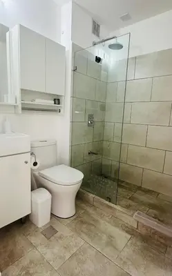 a bathroom with a toilet and a glass shower at Secure & Confortable Apartment with green spaces in San Rafael