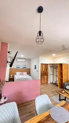a bedroom with a bed and a pink wall at GZ Suites in Coco