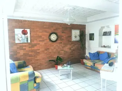 a living room with a couch and a brick wall at Casagerardine in Alajuela City