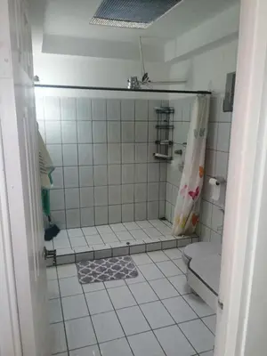 a bathroom with a shower and a tiled floor at Casagerardine in Alajuela City