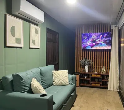 a living room with a blue couch and a tv at Casa el Manú Finca Agroecologíca in Marsella