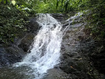 a waterfall on the side of a rocky hill at Casa Castillo in Quepos