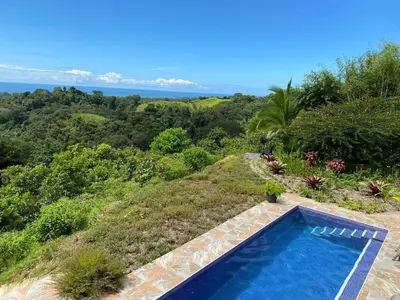 a swimming pool with a view of the ocean at Casa Castillo in Quepos