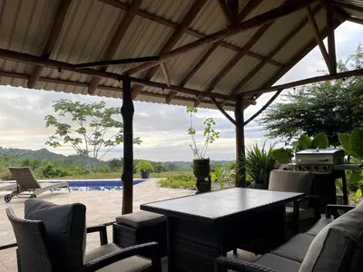 a patio with a table and chairs under a pavilion at Casa Castillo in Quepos