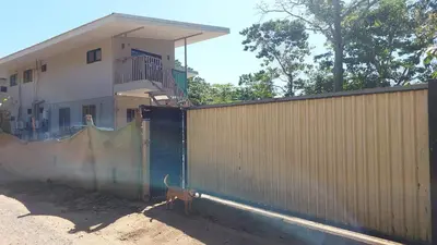 a dog standing behind a fence next to a building at Pura Vida Jungle Retreat 1 Bed Up in Montezuma