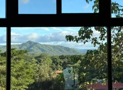 a window with a view of a river and mountains at Casa Ángel in Matapalo