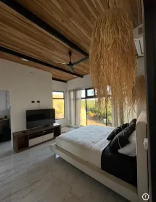 a bedroom with a large bed and a television at Casa Ángel in Matapalo