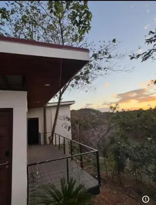 a house with a balcony with a view of the mountains at Casa Ángel in Matapalo