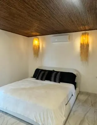a bedroom with a bed with two lights on the wall at Casa Ángel in Matapalo
