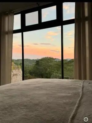 a bedroom with a large window with a view at Casa Ángel in Matapalo