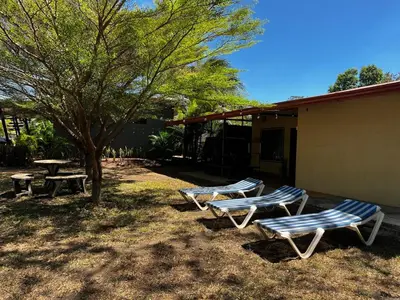 four lounge chairs and a picnic table and a tree at 3-bedroom accommodation in Tamarindo in Garita