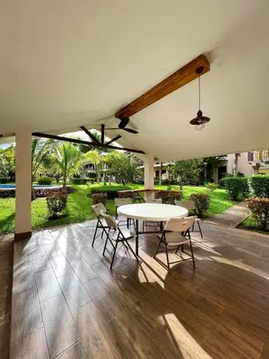 a patio with a table and chairs on a wooden floor at Sea Heaven Ground Floor Studio in Coco