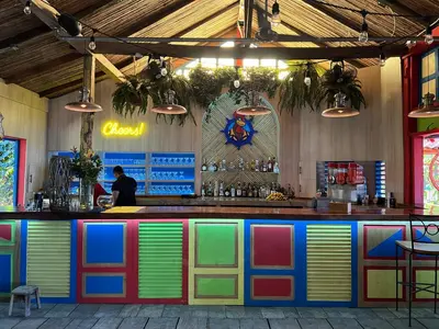a colorful bar in a restaurant with a man behind the counter at Sea Heaven Ground Floor Studio in Coco