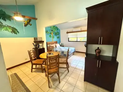a living room with a table and a bedroom at Calm & Palms Second Floor Studio in Coco