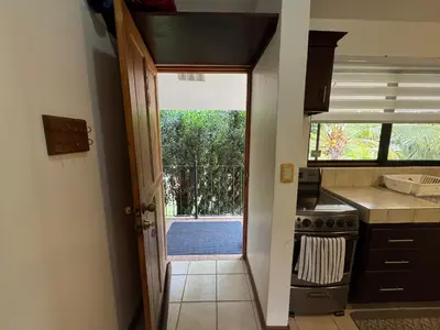 a kitchen with a door leading to a pool at Calm & Palms Second Floor Studio in Coco