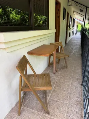 two benches and a table on the side of a building at Calm & Palms Second Floor Studio in Coco