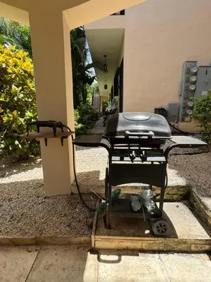 a bbq grill sitting outside of a building at Calm & Palms Second Floor Studio in Coco