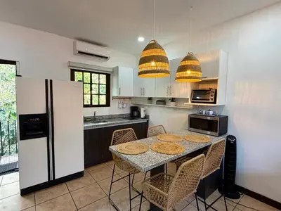 a kitchen with a table with chairs and a refrigerator at Plaza Colonial Second Floor One Bedroom Unit in Coco