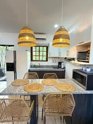 a kitchen with a table with chairs and lights at Plaza Colonial Second Floor One Bedroom Unit in Coco