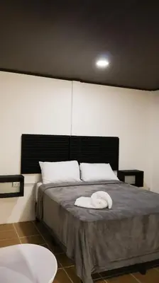 a bedroom with a bed with a white towel on it at Palma Roots in Jacó