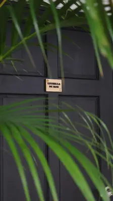 a black garage door with a sign on it at Palma Roots in Jacó