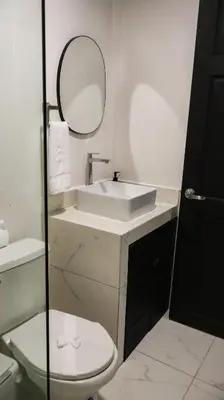 a bathroom with a sink and a toilet and a mirror at Palma Roots in Jacó