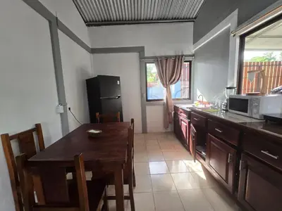a kitchen with a wooden table and a microwave at Stay at Alexas Nature House in Nuevo Arenal
