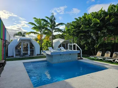 a pool with a table and chairs next to a house at Arenal Igloo Private House in Fortuna