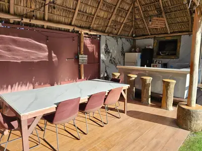a table and chairs in a room with a bar at Arenal Igloo Private House in Fortuna