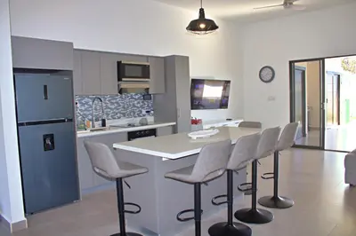 a kitchen with a table and chairs and a refrigerator at Villa Libélula in Quepos