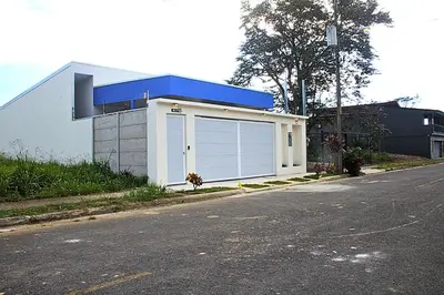 a white garage with a blue roof on a street at Villa Libélula in Quepos